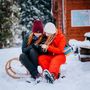 GPS Tracking im Winterwald Zwei Freundinnen verschnaufen im Schnee auf ihrem Schlitten. Sie haben ein GPS Gerät in der Hand und überprüfen ihre Koordinaten.